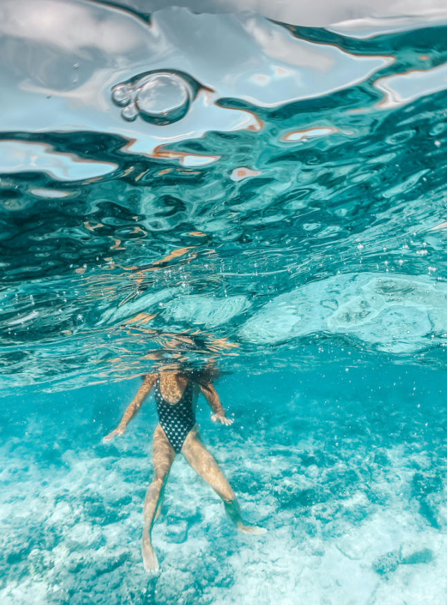 Uma imagem de alguém a nadar no mar azul profundo, representando visualmente o conceito de uma descoberta aprofundada.