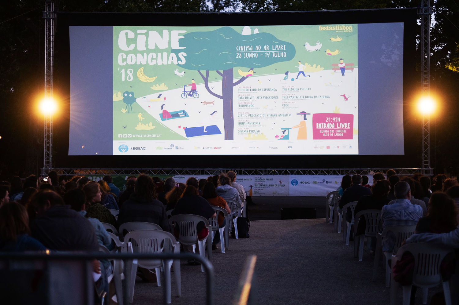 Vista da projeção do cartaz no festival. Aplicação de design em formato digital, comunicando a identidade visual no ambiente do evento.