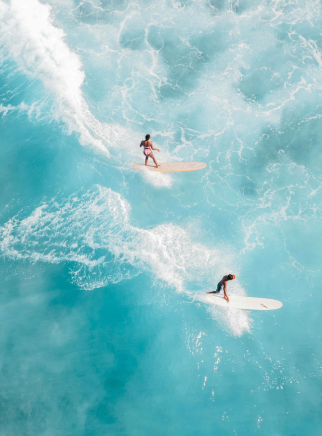 Vista aérea de dois surfistas em cima na água, seguindo um rumo, simbolizando o caminho com propósito.