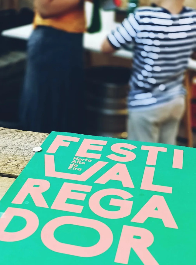 Vista aproximada de parte de um cartaz de evento, realçando o ângulo de observação e a execução final do design visual impresso.